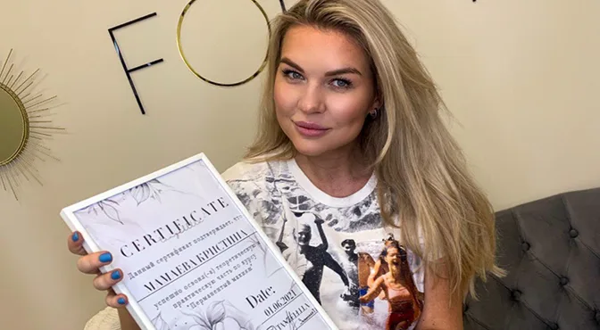 A graduate holding her certificate of completion